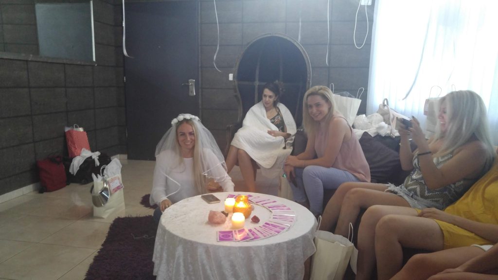 מסיבת רווקות כלה יושבת ליד שולחן עם הקלפים